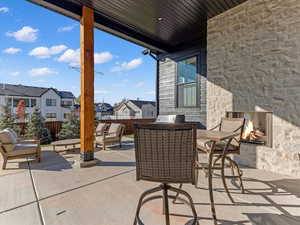 Fenced backyard featuring a patio, a residential view, and an outdoor living space with a fireplace