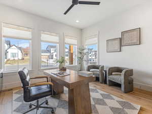 Office space with light wood finished floors, plenty of natural light, ceiling fan, and recessed lighting