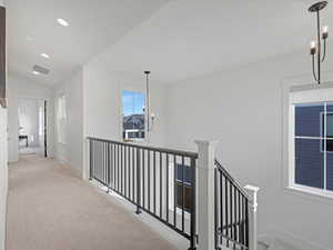 Hall with a chandelier, light carpet, an upstairs landing, recessed lighting, and lofted ceiling