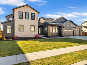 Modern farmhouse featuring board and batten siding, concrete driveway, and a garage