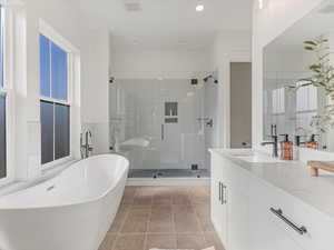 Full bathroom with a freestanding tub, vanity, a shower stall, light tile patterned floors, and recessed lighting