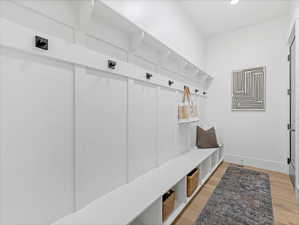 Mudroom with light wood finished floors and baseboards