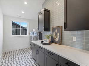 Kitchen with decorative backsplash, light stone countertops, light flooring, recessed lighting, and washing machine and dryer