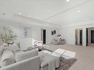 Carpeted living room with recessed lighting and a raised ceiling