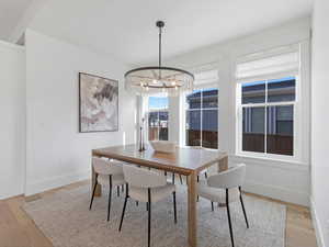 Dining area featuring light wood finished floors and a chandelier