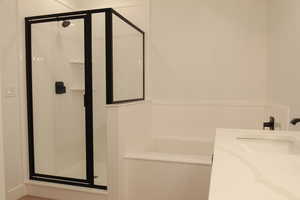 Bathroom featuring vanity, a shower stall, and a bath