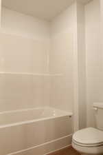 Bathroom featuring wood finished floors and shower / washtub combination
