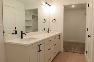 Bathroom featuring double vanity and light wood-style floors