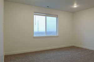 Empty room featuring baseboards and carpet