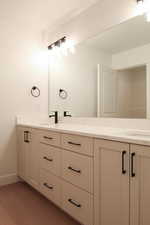 Full bathroom with double vanity and light wood-style floors