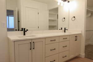 Bathroom with double vanity and a spacious closet