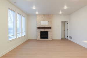 Unfurnished living room featuring light wood-style flooring and a fireplace