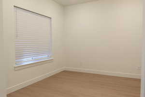 Spare room with baseboards and light wood finished floors