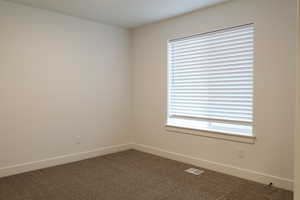 Spare room with baseboards and carpet floors