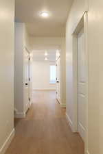 Hall featuring light wood-style flooring and baseboards