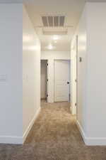 Hallway with carpet floors and baseboards