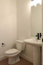 Half bath featuring baseboards and dark wood finished floors