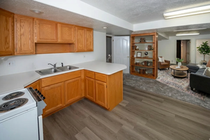 Kitchen with a peninsula, light countertops, a textured ceiling, electric range, and open floor plan