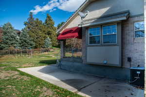 View of side of home featuring stucco siding and a patio area