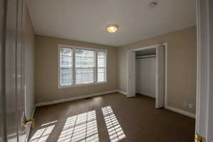Unfurnished bedroom with carpet and a closet