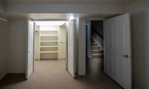 Hall featuring light colored carpet and stairs