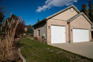 View of home's exterior with brick siding, driveway, and a garage