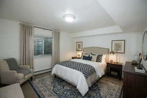 Bedroom with carpet and a baseboard heating unit