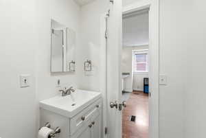 Half bath with vanity and wood finished floors