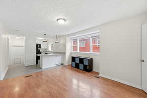 Unfurnished living room with a textured ceiling and light wood-style flooring