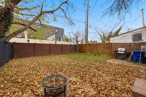 Fenced backyard featuring a fire pit