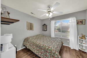 Bedroom featuring dark wood-style floors and a ceiling fan