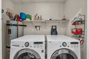 Laundry room with water heater and washer and dryer