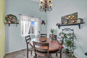 Dining room featuring a chandelier and baseboards