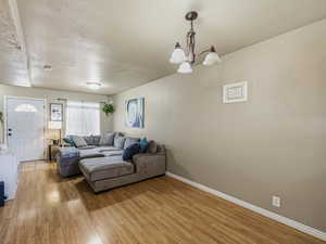 Living room with light wood-style flooring and a chandelier