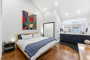 Bedroom with wood-type flooring, high vaulted ceiling, recessed lighting, and ensuite bathroom