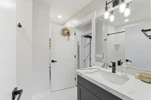 Bathroom featuring vanity, a shower, and recessed lighting