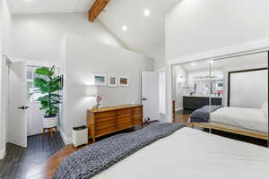 Bedroom with dark wood-style floors, beam ceiling, high vaulted ceiling, and recessed lighting