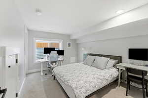 Bedroom with an office area, light colored carpet, and recessed lighting