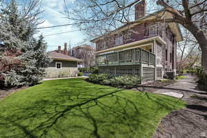 Back of house with a chimney and a lawn
