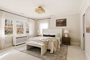 Bedroom with carpet, radiator, and ornamental molding