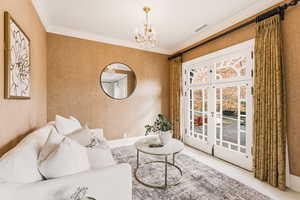 Sitting room with french doors, ornamental molding, and a chandelier