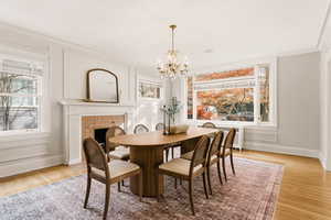 Dining area with light wood-type flooring, a chandelier, radiator heating unit, plenty of natural light, and ornamental molding