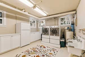 Washroom featuring finished concrete floors, cabinet space, and separate washer and dryer
