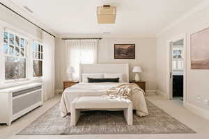 Bedroom featuring radiator heating unit, ornamental molding, and carpet