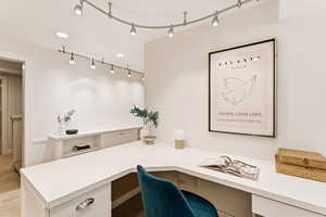 Office area featuring built in desk and light colored carpet