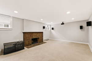 Unfurnished living room featuring a tile fireplace, carpet, recessed lighting, and a baseboard heating unit