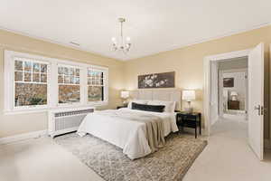 Bedroom with radiator, light carpet, and a chandelier
