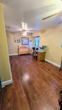 Bedroom with dark wood-type flooring and baseboards