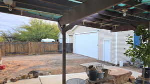 View of patio looking towards the oversized garage and yard