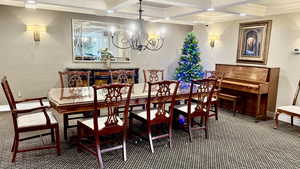 Carpeted dining space with crown molding, coffered ceiling, a chandelier, beamed ceiling, and recessed lighting